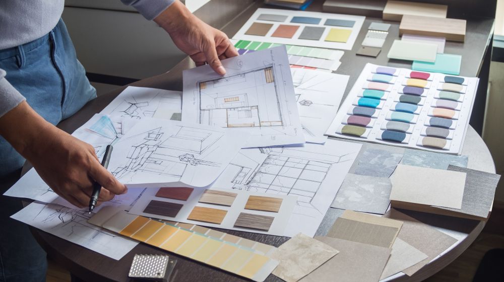 A person with sketch drawings of a new office on a table